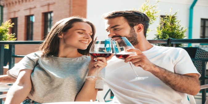 a smiling couple is drinking wine